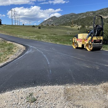 ACME Asphalt roller compacting fresh asphalt on a rural roadway